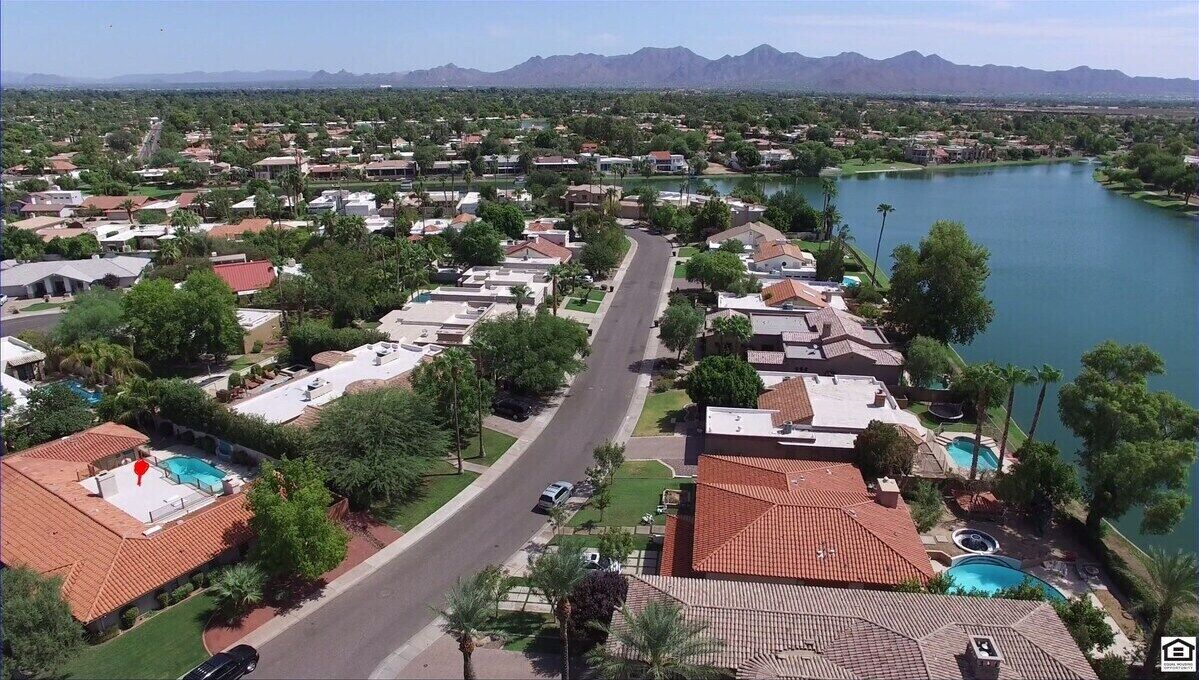 Un quartier résidentiel avec des maisons, une route et un lac.