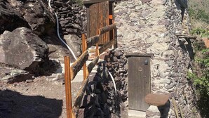 A stone building with a wooden staircase leading to a wooden door. - Les Ecrins de Belvedere (Belvedere)