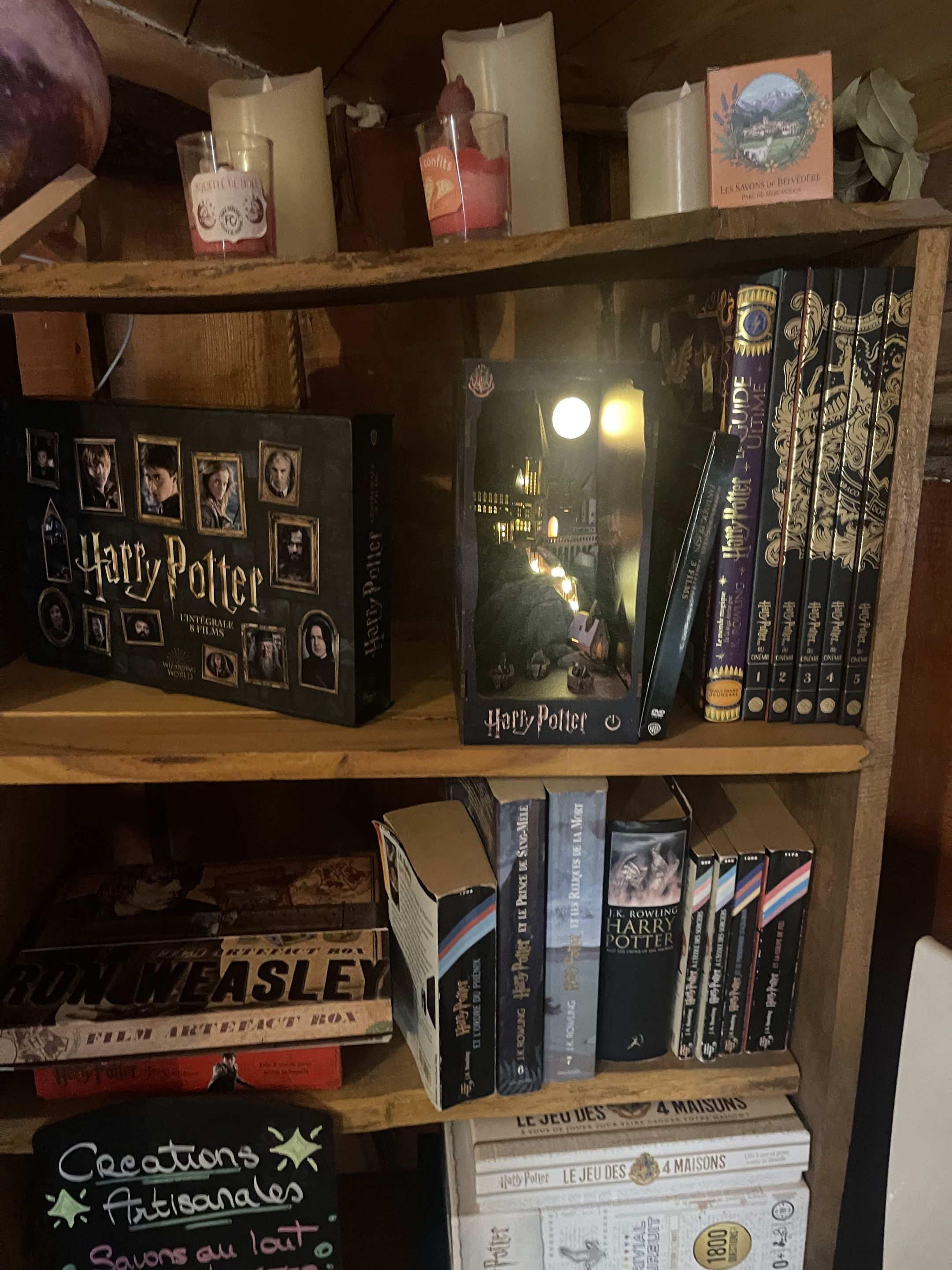 A bookshelf with various books, including a Harry Potter box set and a Harry Potter-themed display.