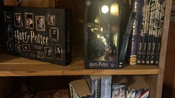 A bookshelf with various books, including a Harry Potter box set and a Harry Potter-themed display.