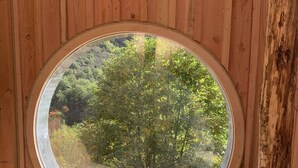 A circular skylight with a wooden deck below, surrounded by wooden walls. - Les Ecrins de Belvedere (Belvedere)