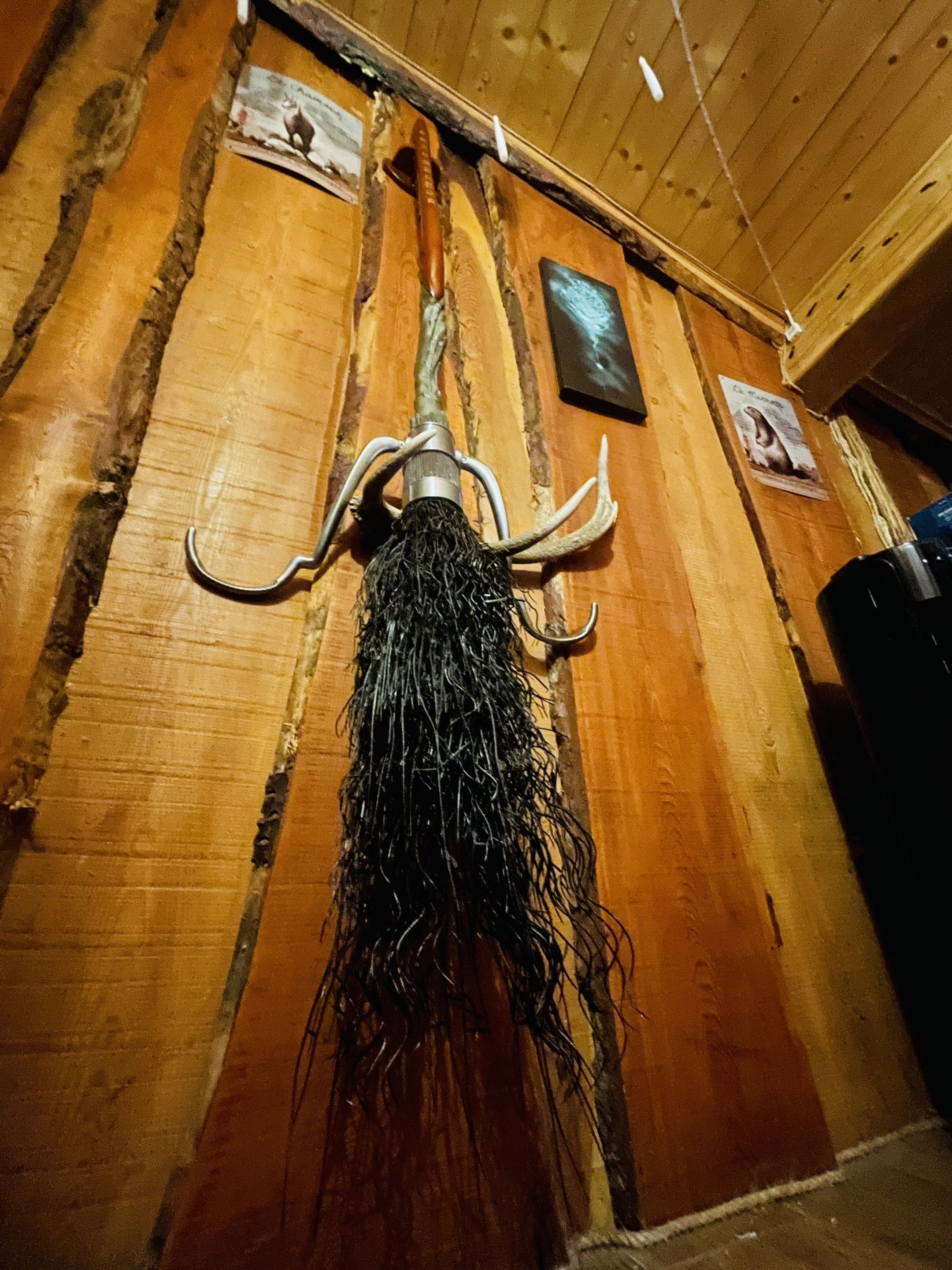 A rustic wooden wall with a decorative metal object hanging from it.