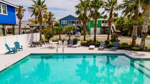Une piscine avec des chaises longues et une clôture blanche.