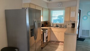 A modern kitchen with stainless steel appliances, wooden cabinets, and a built-in oven. - Sunsational Seahorse- Nice and Relaxing
2/2 Sleeps 6 (New Port Richey)