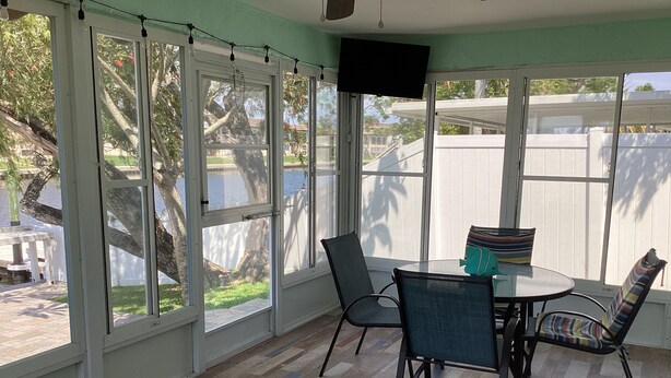 A sunlit room with large windows, a glass table, and chairs. - Sunsational Seahorse- Nice and Relaxing
2/2 Sleeps 6 (New Port Richey)