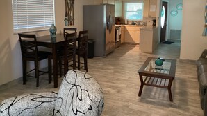 A spacious living room with a dining area, kitchen, and a small seating area with a coffee table. - Sunsational Seahorse- Nice and Relaxing
2/2 Sleeps 6 (New Port Richey)
