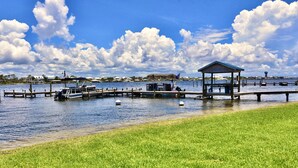 A marina with boats, a dock, a gazebo, and a water tower in the background. - Sundown B 23 (Pensacola)