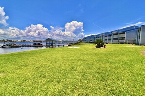 A hotel with a grassy lawn, a dock, and a body of water.