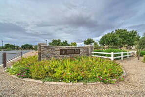 A stone sign for Indigo Sky Recreation Center surrounded by a gravel path and flower beds. - Sensational fully furnished San Tan Valley Home in the Johnson Ranch Community! (San Tan Valley)