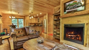 A cozy cabin interior with a fireplace, wooden furniture, and a sign for Mountain Oasis.