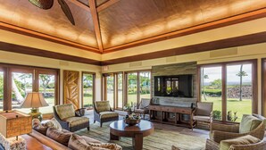 Amplia sala de estar con un televisor grande, asientos cómodos y vistas al exterior.