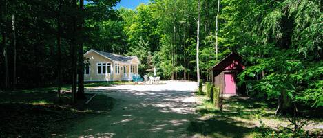 Une zone boisée avec un petit bâtiment et une remise.