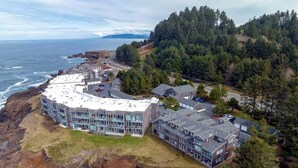 A coastal hotel with a circular building, multiple guest rooms, and a view of the ocean. - The Lighthouse, Whale Watching, Fireplace & Pool (Depoe Bay)