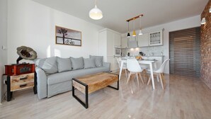Una sala de estar moderna con sofá, mesa de centro y comedor con sillas y una mesa.