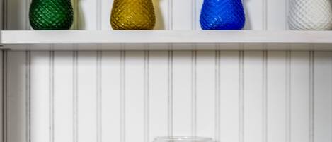 A shelf with colorful glass bottles and starfish decorations.