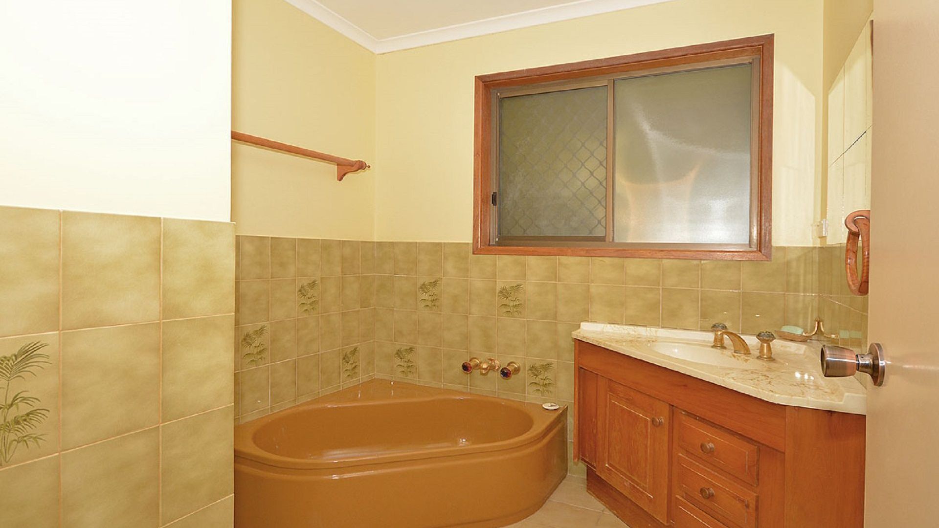 Une salle de bain avec une baignoire, un meuble-lavabo et une fenêtre située au-dessus du meuble-lavabo.