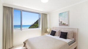 A hotel room with a large window offering a view of the ocean and a beach. - Kirra Gardens 17 - Kirra Point Beachfront (Coolangatta)