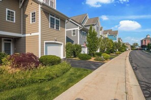Stylish townhouses line this well-manicured street with garages and beautifully maintained lawns.