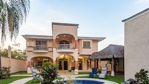 A two-story house with a swimming pool, outdoor seating, and a thatched-roof structure. - Breakfast Included w/pool 5rooms/5bath for 15 (Centro)