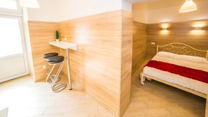 A modern bedroom with a bed, a small table, and a stool. - Smart Apartment Teodora 5b (Lviv)