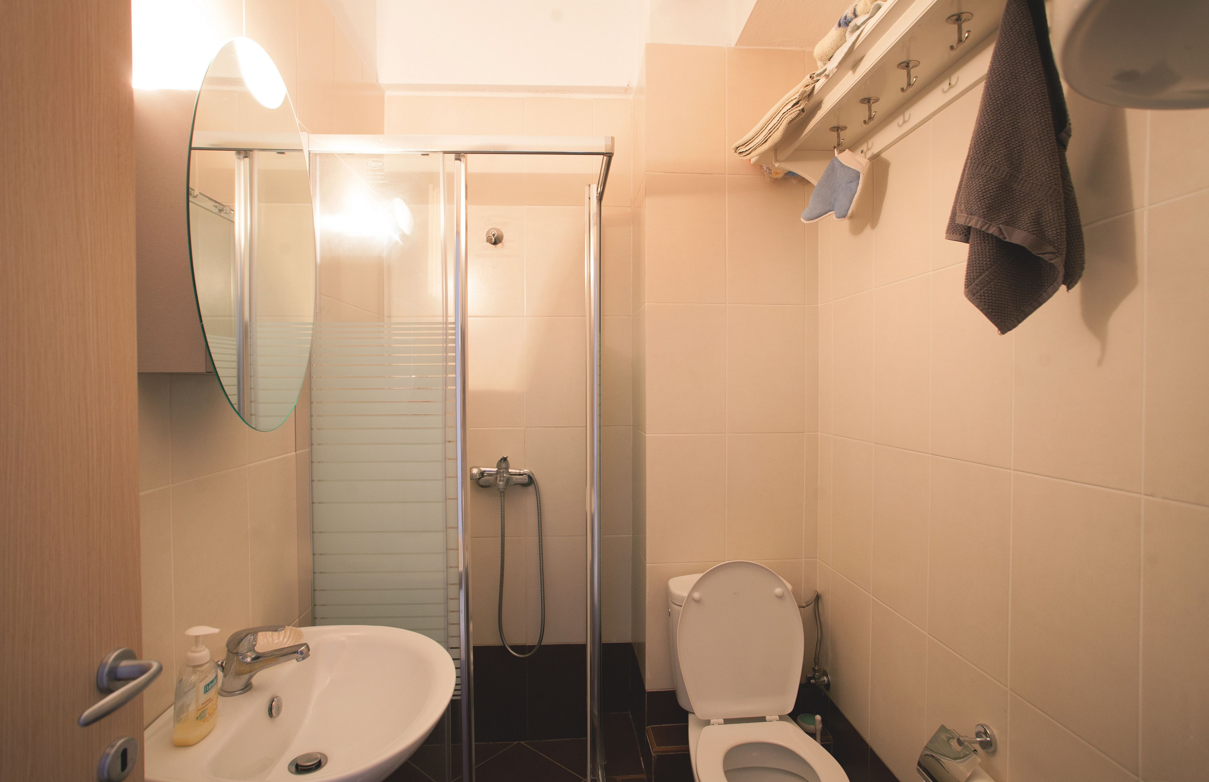 Ein Badezimmer mit Duschkabine aus Glas, Waschbecken und Toilette.