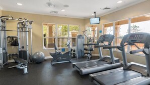 Ein Fitnessraum mit Laufbändern, Kraftgeräten und Übungsbällen.