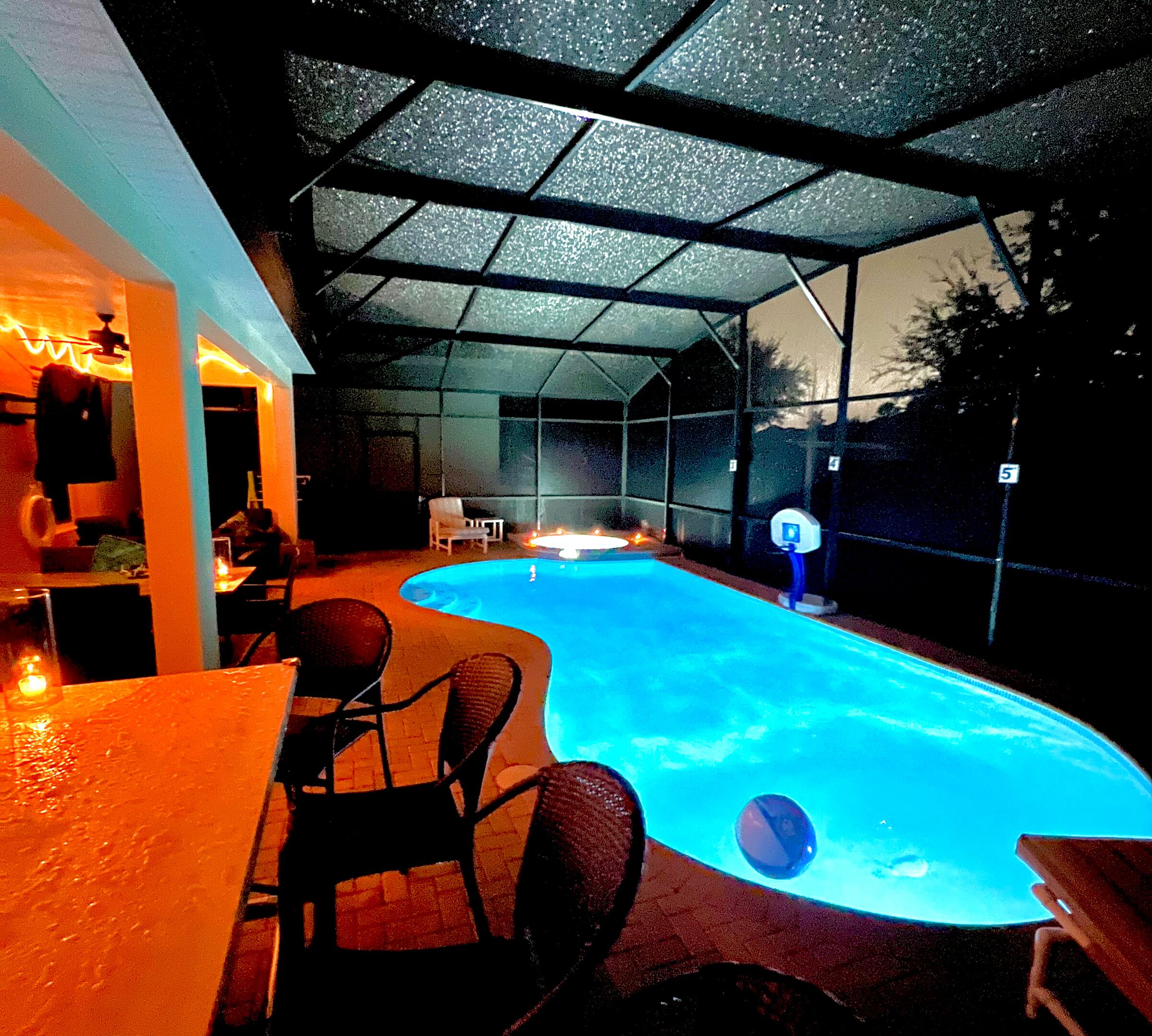 Ein Außenpool mit überdachtem Bereich, einer Bar und Sitzgelegenheiten.