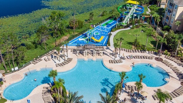 Ein Resort mit großem Pool, Wasserpark und Palmen.