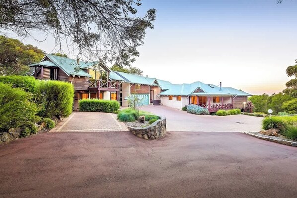 A property with a central building, a covered outdoor area, and a driveway.