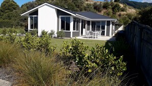 A modern house with a large patio, surrounded by natural vegetation and hills. - Family Executive House (Pohara)