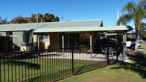 A building with a flat roof, a fenced outdoor area, and a sign that reads "Palmgrove." - Palmgrove 1 - Rainbow Beach. Gorgeous, modern beach escape in a great location. Aircon. Wifi (RAINBOW BEACH)