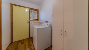Une buanderie équipée d’un lave-linge, d’un sèche-linge et d’un meuble de rangement.