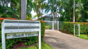 Ein begrenzter Zugang zu einer Anlage namens 'Beach Villas' mit einem Schild, das die Anzahl der Zimmer angibt.