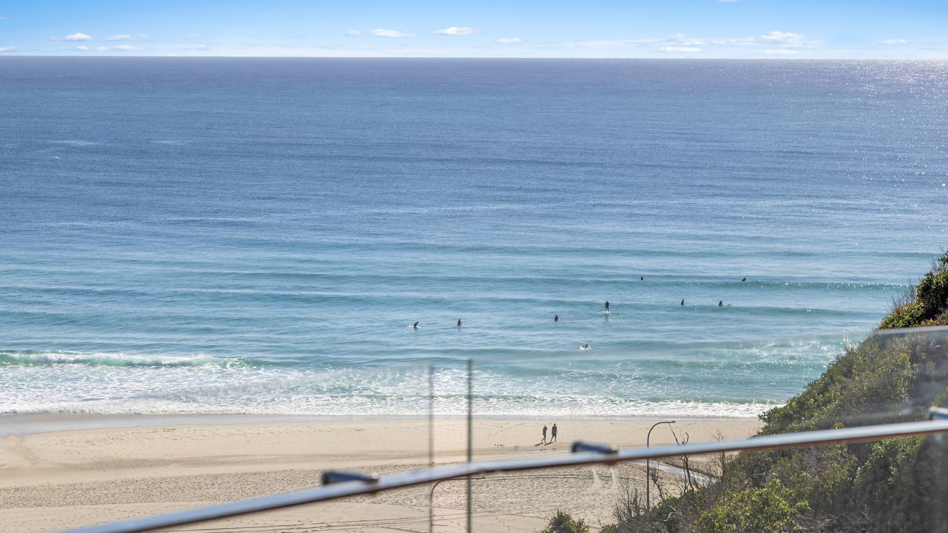 A beach with a clear view of the ocean and a sandy shore.