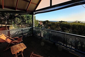 Un espacio al aire libre cubierto con vista al paisaje, incluyendo árboles y un molino de viento a lo lejos.