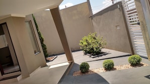 A courtyard with a small tree, a potted plant, and a tiled floor. - Recanto da Bia, 3 bedrooms, air conditioning, Wi-Fi and 4 minutes from the park. (Olímpia)