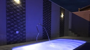 A rectangular hot tub with a faucet, surrounded by a tiled floor and walls with a geometric pattern. - Recanto da Bia, 3 bedrooms, air conditioning, Wi-Fi and 4 minutes from the park. (Olímpia)