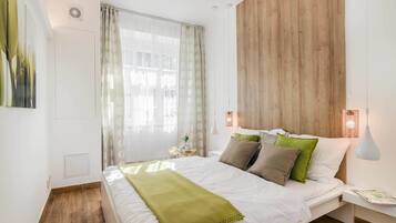 Ein Schlafzimmer mit einem großen Bett, einem Holzkopfteil und einem Nachttisch mit Lampe.