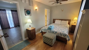 Cozy retreat with a comfortable bed, bedside table, and nightstand, plus a convenient door to the next room.