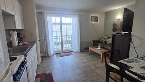 A compact living space with a kitchenette, a dining area, and a seating area. - Home Away From Home 2 (Hampton Beach)
