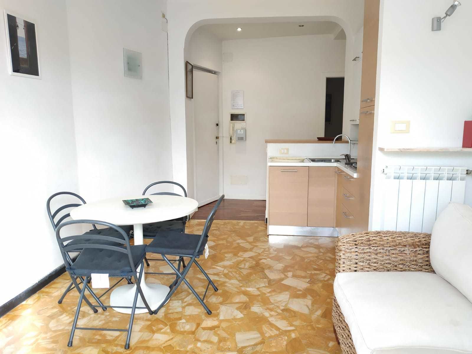 Un espace de vie compact comprenant un coin repas, une kitchenette et un coin salon.