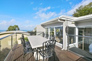 A deck with a table and chairs, overlooking a scenic view. - On The Deck (Lorne)