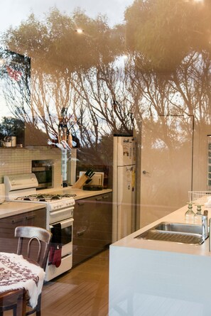 Eine moderne Küche mit einer Kochinsel, einem Herd, einem Backofen und einem Kühlschrank.