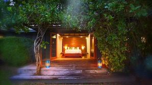 A cozy, well-lit bedroom with a wooden bed and two lanterns on either side. - Beachfront Luxe Villa Escape — Infinity Pool, Views, and Resort-Style Service (Savusavu)