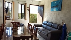 Un comedor con una mesa y sillas, un sofá y un ventilador de techo.