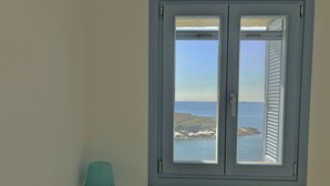 Une pièce avec vue sur la mer, donnant sur une fenêtre munie de volets.