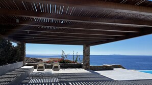 Un espace extérieur abrité, doté de murs en pierre et offrant une vue sur la mer.