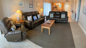 Ein Wohnzimmer mit zwei Ledersofas, einem Holztisch und einem kleinen Beistelltisch mit Lampe.