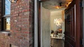 A brick exterior wall with a wooden door and a window.
