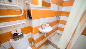 A bathroom with a white toilet, a sink, and a shower area. - Smart Apartment Filatova 10v (Lviv)